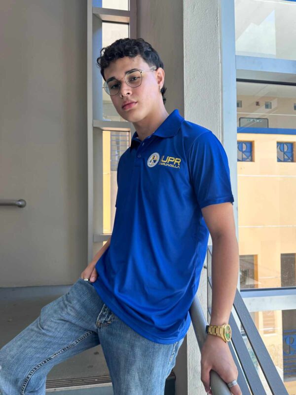 joven varón modelando polo azul con logo representativo de la UPR Aguadilla