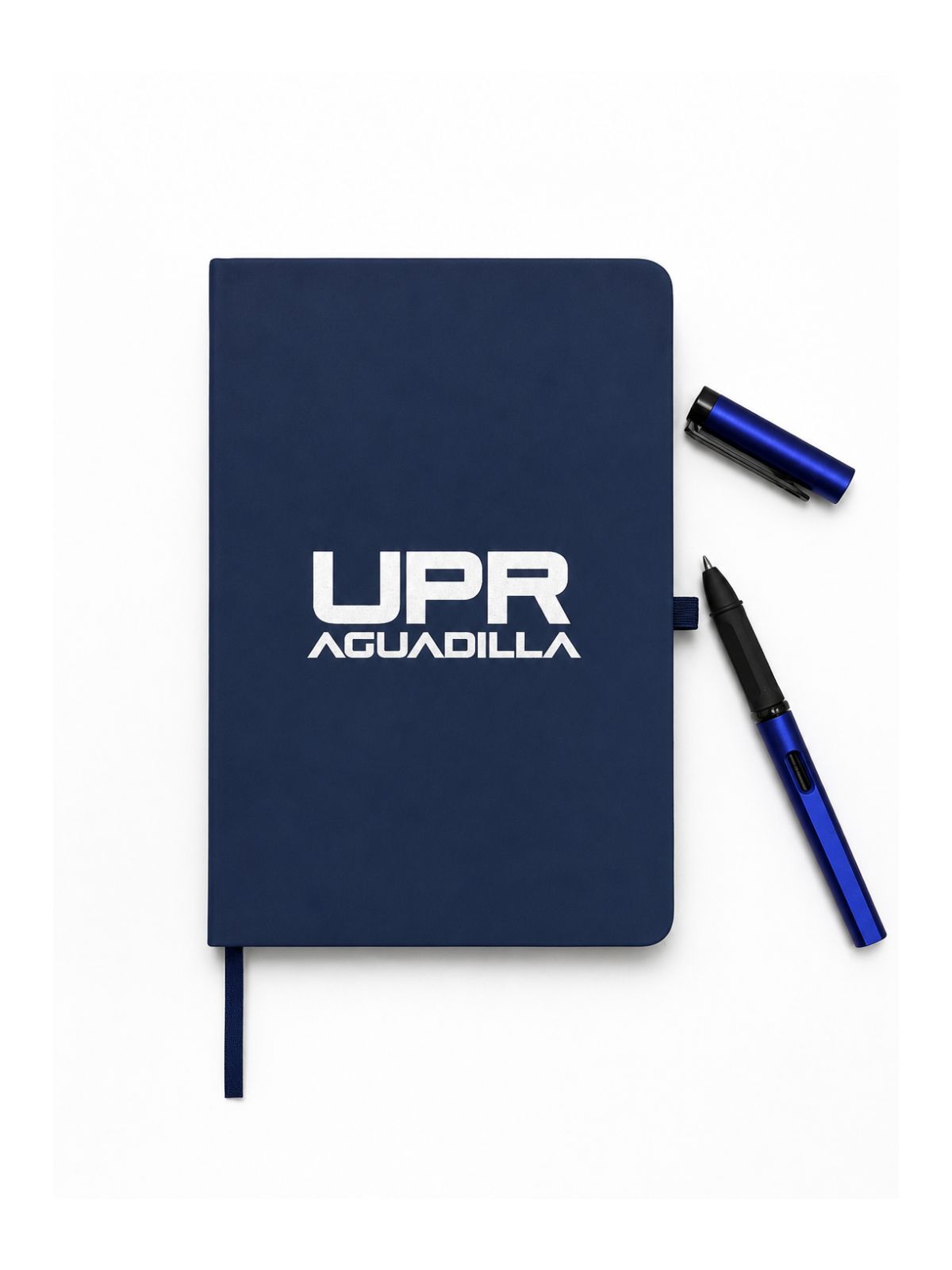 libreta azul oscuro con estampado UPR Aguadilla en color blanco y bolígrafo azul metálico abierto