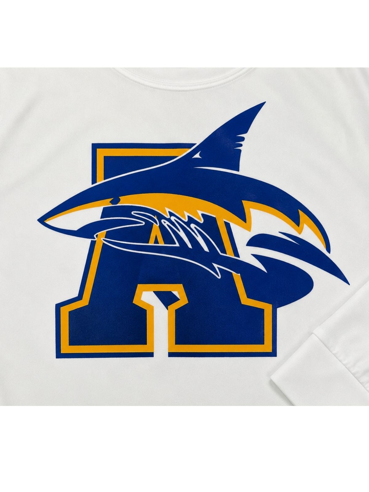 Detalle de estampado frontal de camisa playera blanca de letra insignia A con tiburón en azul royal y amarillo